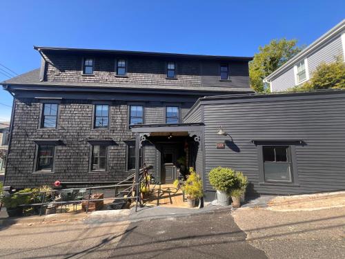 プロビンスタウンにあるCrew's Quarters Boarding House - Caters to Menのガレージ付きの大きな灰色の家