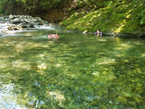 two people in the water in a river at Tanigawa Valley Lodge & Coffee Roastery in Minakami