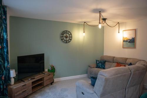 a living room with a couch and a flat screen tv at 4-Bed, Sleeps 6, contractors welcome! in Peterborough