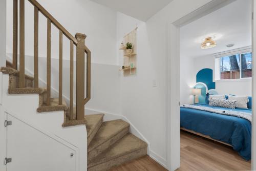 a bedroom with a blue bed and stairs at Luxury 2BR 2BTH Suite 5 Mins to The Falls Sleeps 6 in Niagara Falls