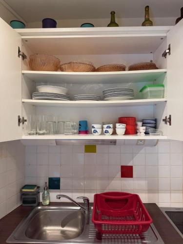 - un comptoir de cuisine avec évier, assiettes et bols dans l'établissement Pti Case, à Dinard