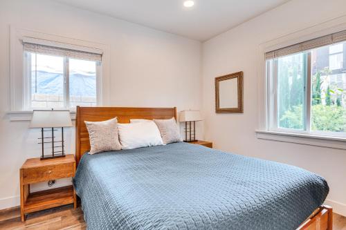 Un dormitorio con una cama azul y dos ventanas. en Convenient Los Angeles Retreat about 1 Mi to Downtown!, en Los Ángeles