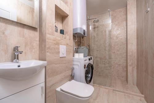 a bathroom with a toilet and a sink and a shower at Wave Apartments - Dobra Voda in Bar