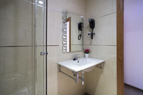 y baño con lavabo y ducha. en Hostal Drassanes, en Barcelona