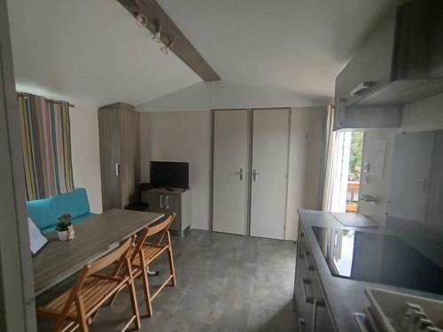a kitchen with a table and chairs in a room at Casinhas Do Alentejano - Lands house Bungalows in Burinhosa