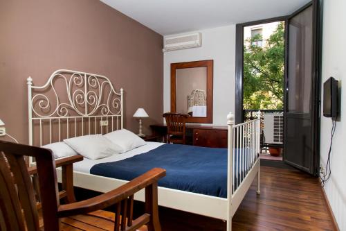 - une chambre avec un lit, un bureau et une télévision dans l'établissement Hostal LK Barcelona, à Barcelone