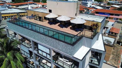 an overhead view of a building with a pool and tables and umbrellas at Porto Kai Residence Flat Vila de Porto de Galinhas 50m do mar in Porto De Galinhas