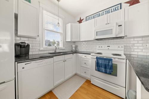Eine weiße Küche mit weißen Geräten und weißen Schränken. in der Unterkunft 36 Meadow View in Cherry Valley