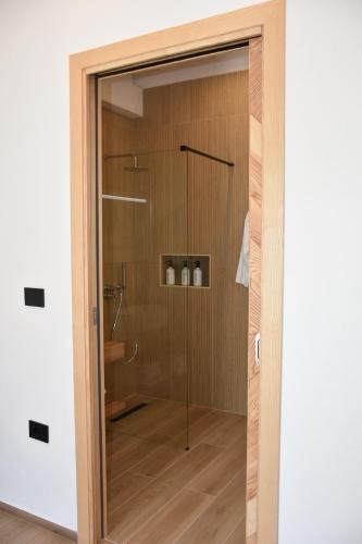 a shower with a glass door in a room at Il Vecchio Casale B&B in Sedini
