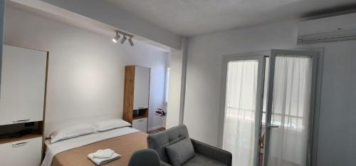 a bedroom with a bed and a chair and a mirror at Old Town City Center 2 in Durrës