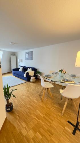 a living room with a table and a blue couch at Boho Bliss Apartments in Delémont