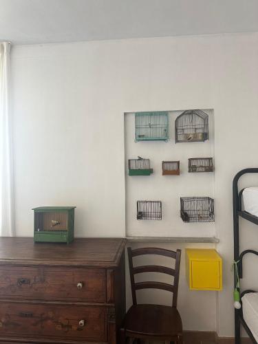 a bedroom with a wooden dresser and bird cages on the wall at Collina Di Sopra in Tresana