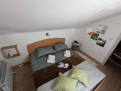 a bedroom with a bed with green sheets and pillows at Apartmani S - DSN in Kraljevo