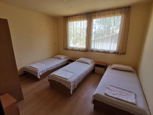 a room with three beds and a window at ELIT Holiday Village in Obzor