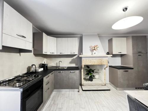 a kitchen with white cabinets and a stove top oven at Casa di Chiara in SantʼAgapito