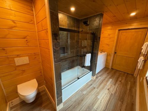 a bathroom with a shower and a toilet and a tub at BC Log cabin with private beach river fire pit AC wifi onsite trails ski slope views in Carroll