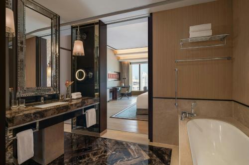 a bathroom with a tub and a large mirror at The St. Regis Mumbai in Mumbai