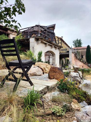une chaise en bois assise devant une maison dans l'établissement Gîte de la Truie qui File, à Noailhac