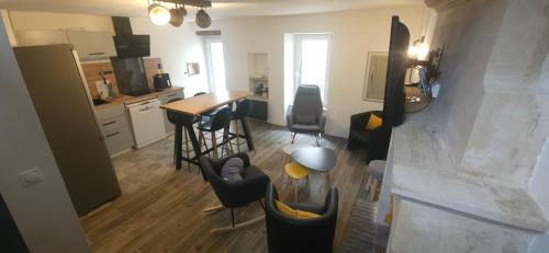 a kitchen and living room with a counter and chairs at les deux pieds sous la couette in Saint-Aubin-sur-Mer