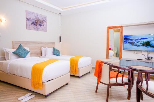 a hotel room with two beds and a table at Adeea Suites Naivasha in Naivasha