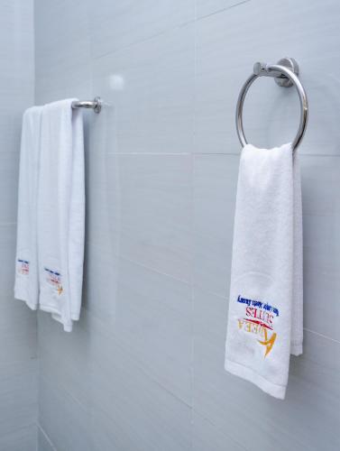 a white towel hanging on a towel rack in a bathroom at Adeea Suites Naivasha in Naivasha