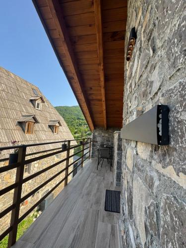 a balcony of a house with a stone wall at Bujtina Carku in Theth
