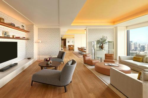 a living room with a couch and a tv at Bvlgari Hotel Tokyo in Tokyo