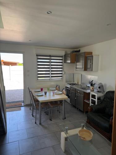 una cucina e un soggiorno con un tavolo e un divano di Le repaire 3 a Saint-Omer-Capelle