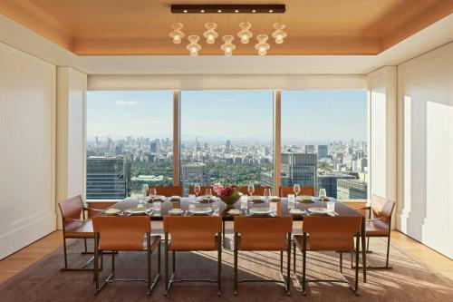 a dining room with a table and chairs and a large window at Bvlgari Hotel Tokyo in Tokyo