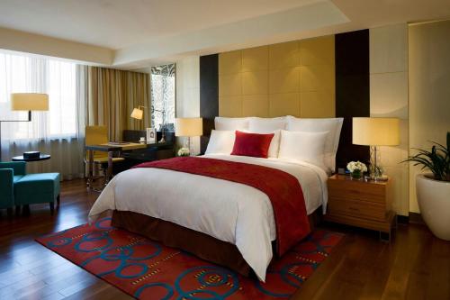 Una habitación de hotel con una cama grande y un escritorio. en The Sandalwood Beijing Marriott Executive Apartments, en Beijing