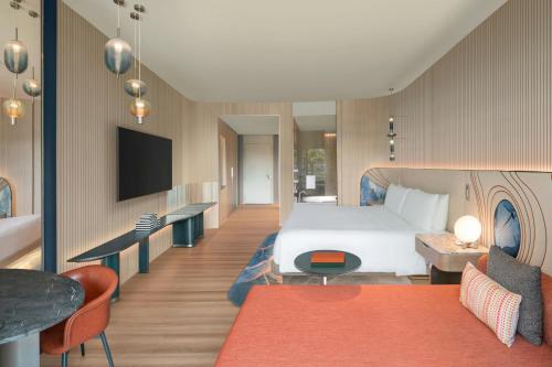 a hotel room with a bed and a tv at W Singapore - Sentosa Cove in Singapore