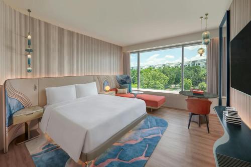 a bedroom with a large white bed and a couch at W Singapore - Sentosa Cove in Singapore