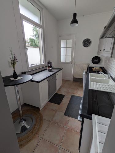 une cuisine avec une table et une fenêtre dans l'établissement Maisonlille, à Lille