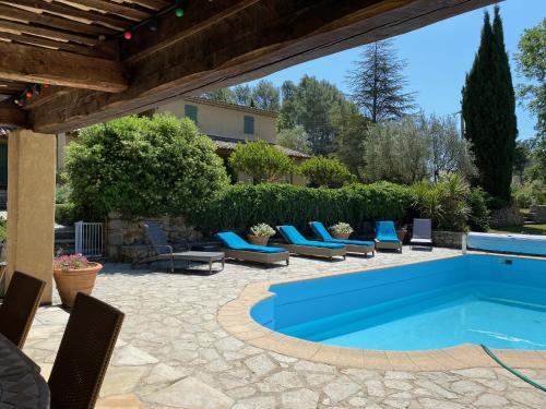 - une piscine sur une terrasse avec des chaises bleues dans l'établissement Mas les Heures Bleues, à Lorgues