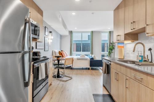 a kitchen with a refrigerator and a living room at Waterfront Studio - Steps from Fishtown and Old City in Philadelphia