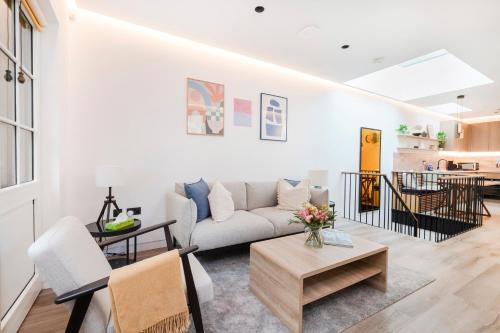 una sala de estar con un sofá y una mesa en Modern 1 bed House in Kensington High St, en Londres