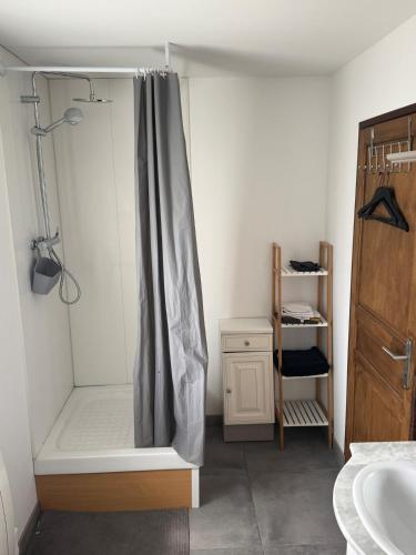 a bathroom with a shower with a shower curtain at Le repaire 2 in Saint-Omer-Capelle