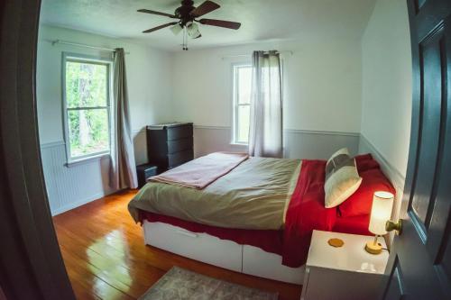 a bedroom with a bed and a ceiling fan at Resting Point - Hot Tub, Firepit, Spacious 4-BR Home in Rogers