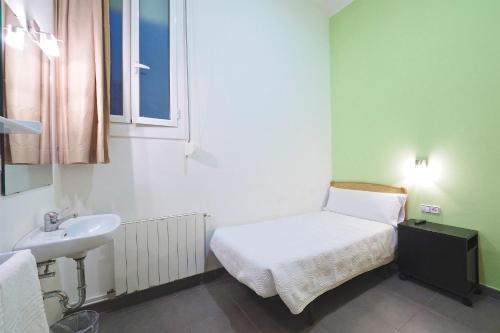 Cette petite chambre comprend un lit et un lavabo. dans l'établissement Pensión Peiró, à Barcelone