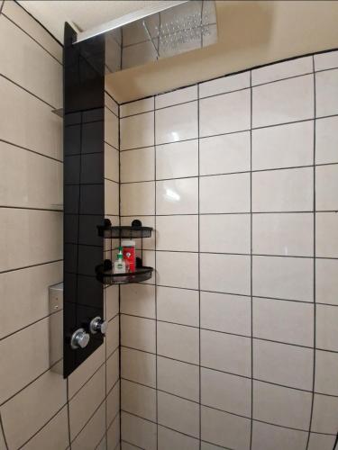 La salle de bains est pourvue d'un mur carrelé blanc. dans l'établissement Appartement Plein Centre, à Saint-Quentin