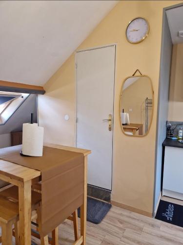 Cette chambre comprend une table, un miroir et une porte. dans l'établissement Appartement Plein Centre, à Saint-Quentin