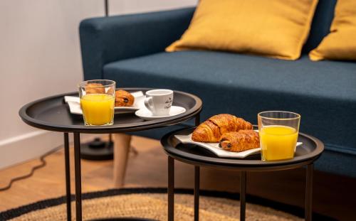 deux tables avec deux verres de jus d'orange et des croissants dans l'établissement Duplex Saveria - Terrace - Netflix - Beach, à Nice