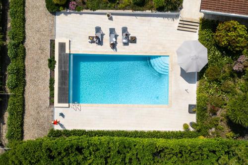 an overhead view of a swimming pool with chairs and an umbrella at HostWise - Modern Villa & Shared Pool in Paredes in Vandoma