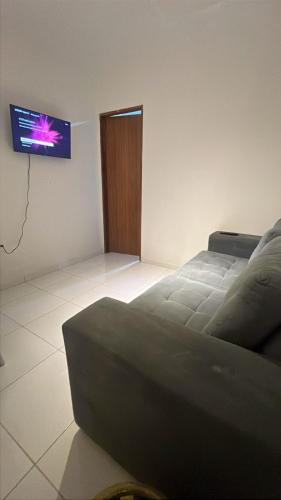 a bedroom with a bed and a tv on the wall at Apto inteiro no centro de caruaru para 2 pessoas in Caruaru