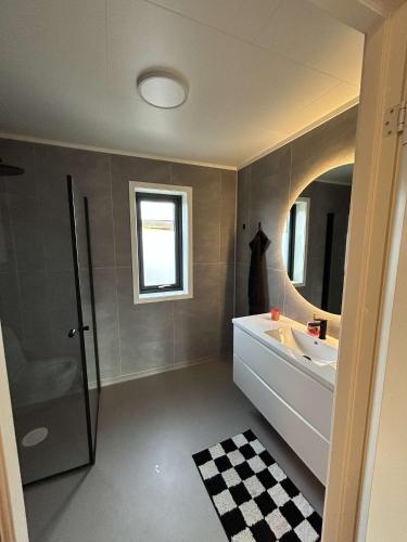 a bathroom with a sink and a shower and a mirror at Nordtoppen in Alta