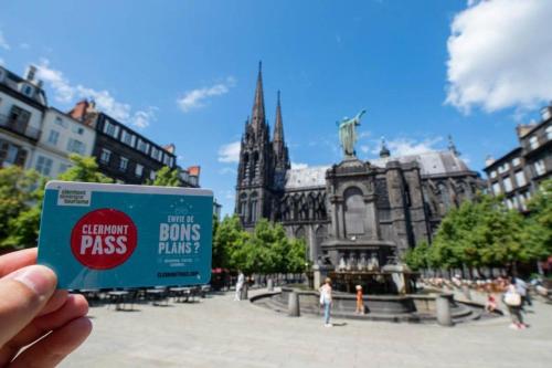 a person holding up a sign in front of a cathedral at Studio - Les Capucins in Riom
