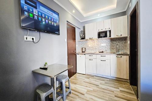a small kitchen with a table and a tv on the wall at Villa Sun Budva in Budva