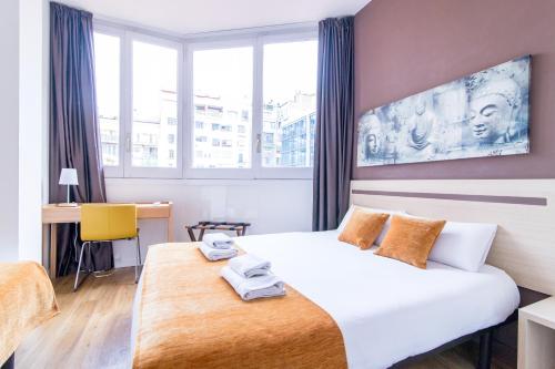バルセロナにあるオスタル バルセロナ セントロのベッドとデスクが備わるホテルルームです。