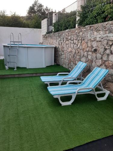 three lounge chairs sitting on the grass next to a wall at Casa rural "Garnacha de Borja" guest home in Borja