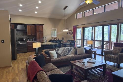 a living room with couches and a table and a kitchen at Elk Run Escape in Show Low